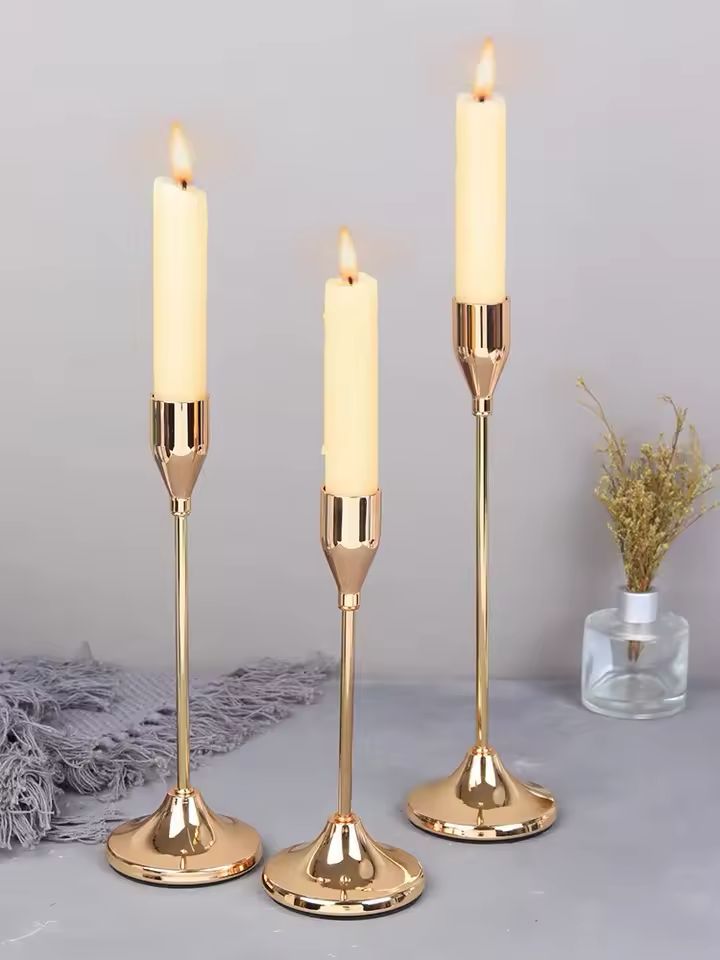 Gold Éclat candle holder set with three lit candles creating a warm and elegant atmosphere for modern home décor.