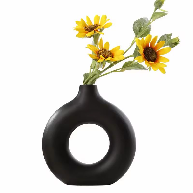 Black Maison Donut ceramic vase with yellow sunflowers, modern minimalist home décor.
