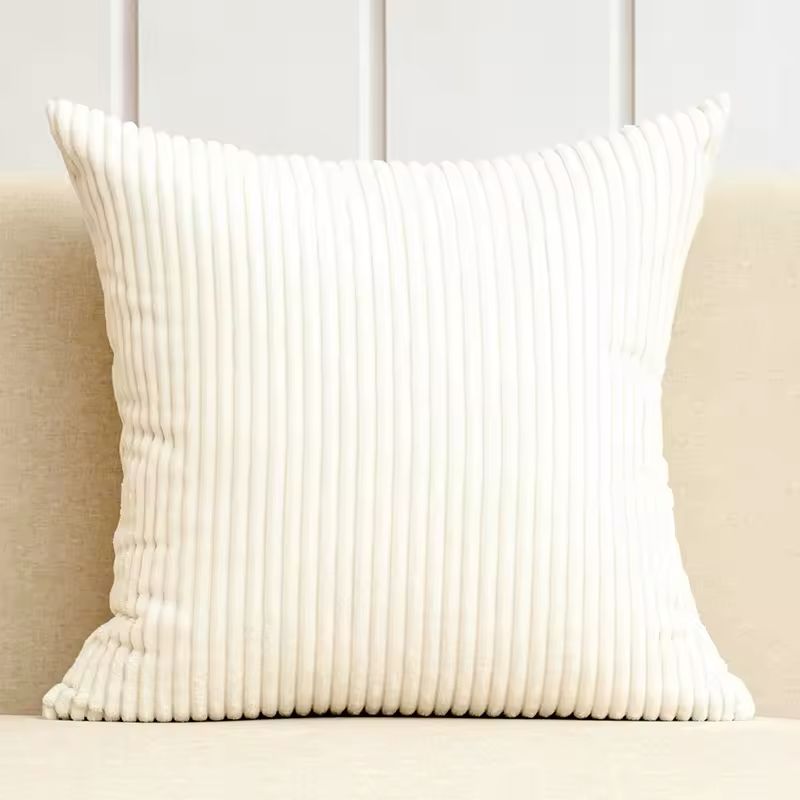 Beige velvet cushion cover on a modern minimalist sofa.